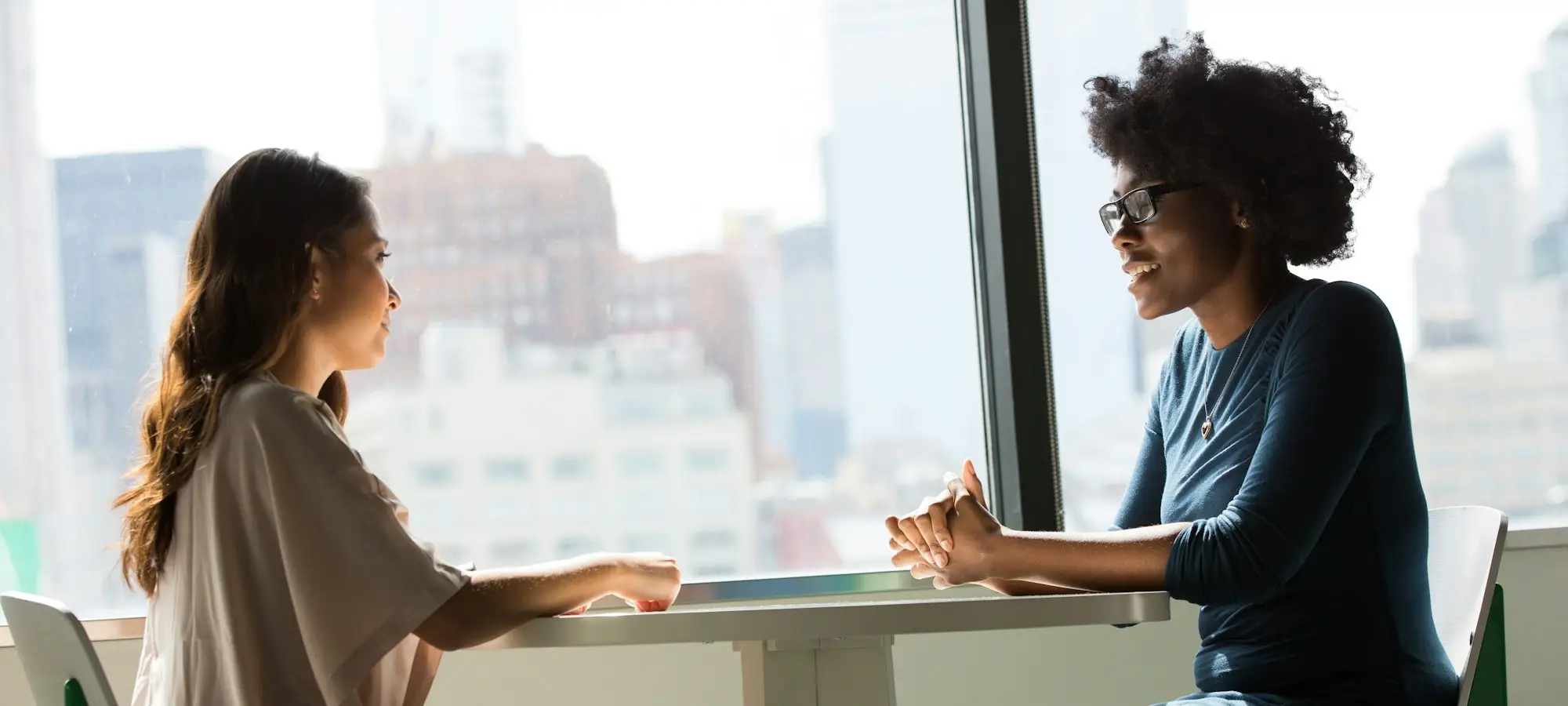 Dos personas conversando en un espacio cálido con luz natural